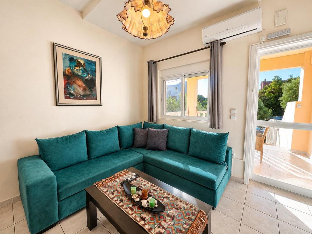 a living room with a green couch and a table at Sun Arise in Porto Rafti