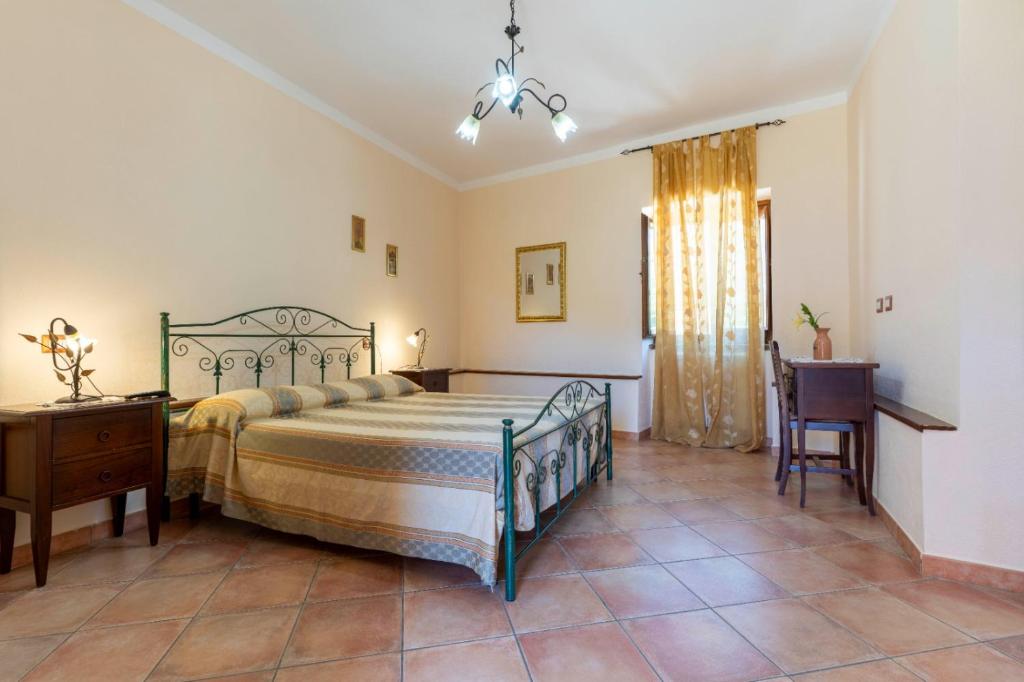a bedroom with a bed and a table and a chair at Country House B&B Antica Dimora Del Sole in Camerota