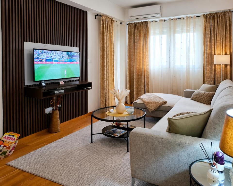 a living room with a couch and a tv at Modern New Apartment Miss T I Free Parking I Great Location in Podgorica