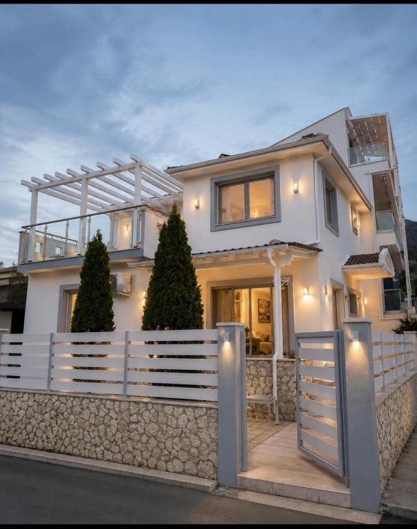 a white house with a fence and trees at Villa Little John in Skala Rachoniou