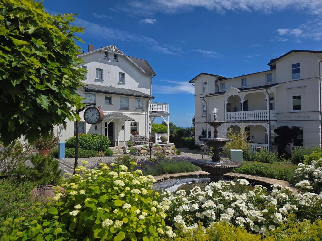 a large white building with a fountain in a garden at Villa Seestern - Ferienhaus mit Meerblick in Sassnitz