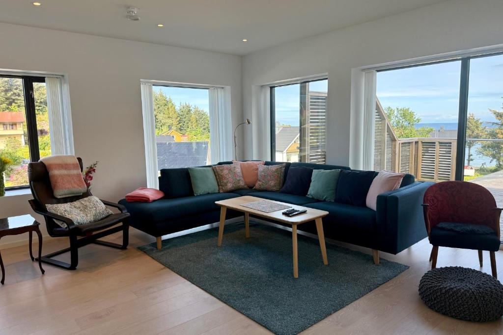 a living room with a blue couch and some windows at LofotenApartmentOne in Stamsund