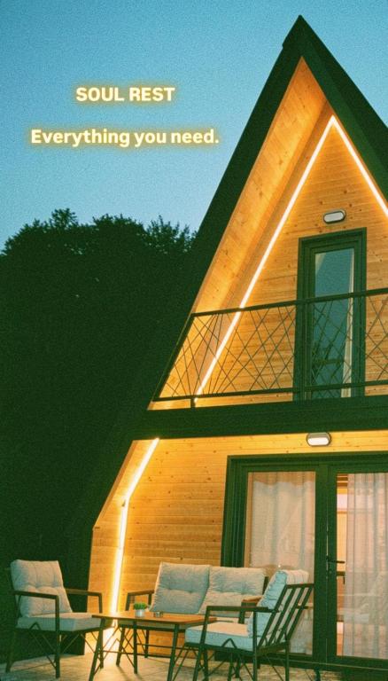 a house with a roof with chairs and a table at Cottage Soul Rest in Visoko