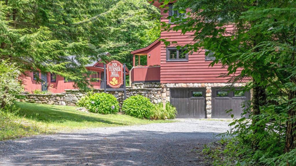 a red house with a garage and a driveway at Luxe Vermont Duplex in Stowe
