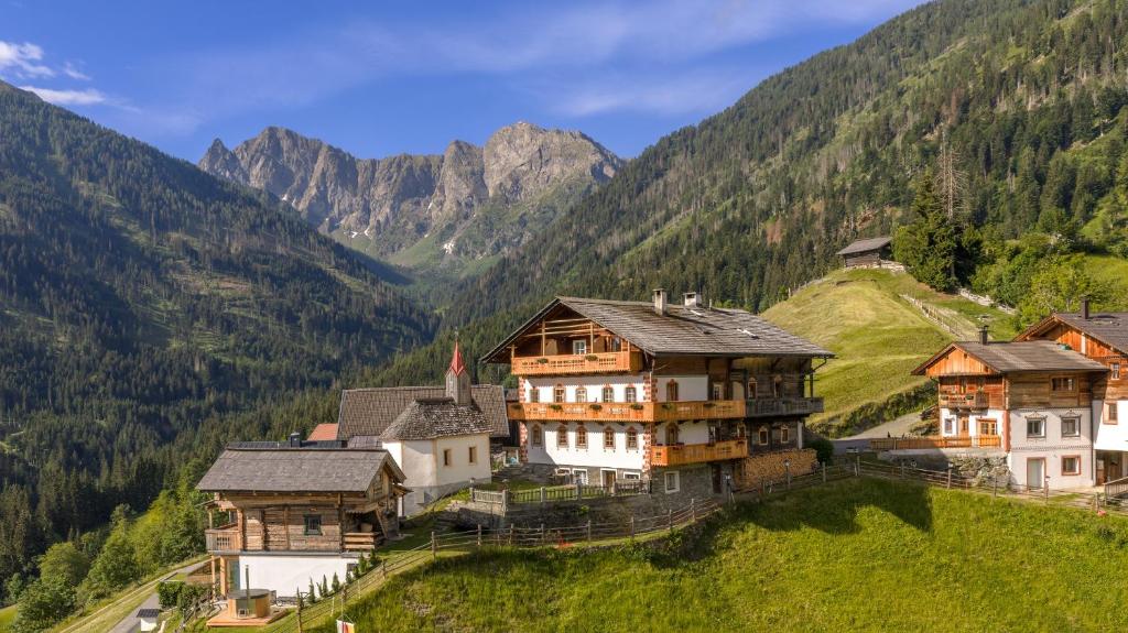 a group of houses on a hill with mountains in the background at Familienwanderhof Eggeler in Liesing