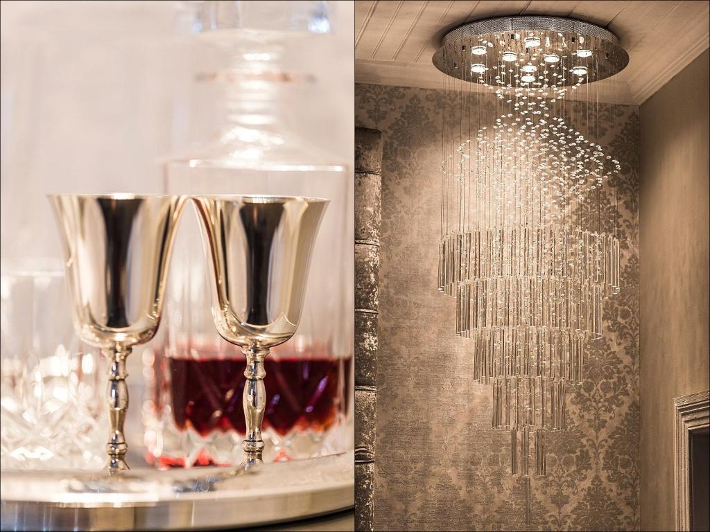 due bicchieri da vino seduti su un tavolo con una bottiglia di The Kingsman boutique Hotel a Burgersdorp