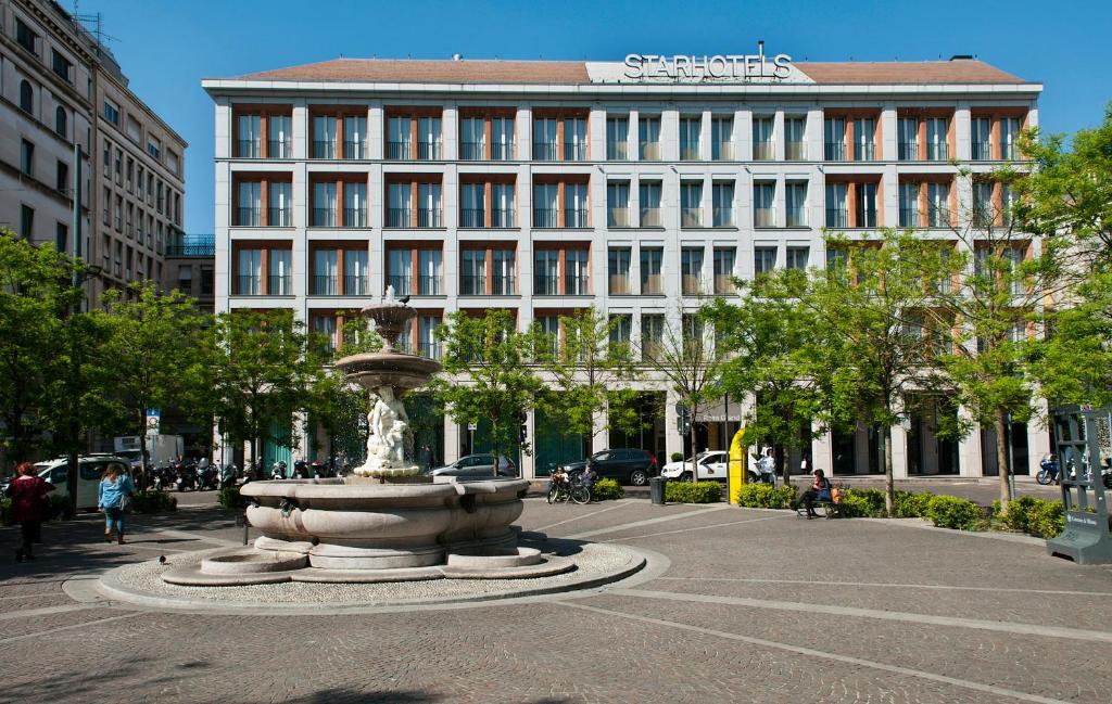 a fountain in the middle of a street with a building at Rosa Grand Milano - Starhotels Collezione in Milan