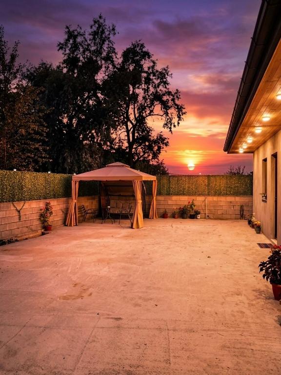 a tent in a patio with a sunset in the background at Green House -მწვანე სახლი in Tsalka