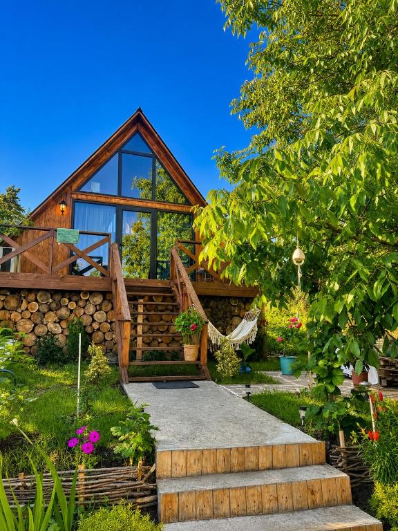 a log cabin with a stone wall and stairs to it at Tasia's Cottage in Tsalka
