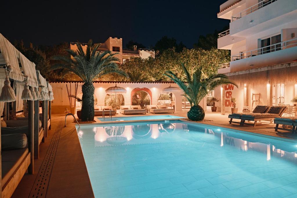 a large swimming pool in a yard at night at The Ibiza Oasis - Adults Only - Sunset Suites in San Antonio Bay