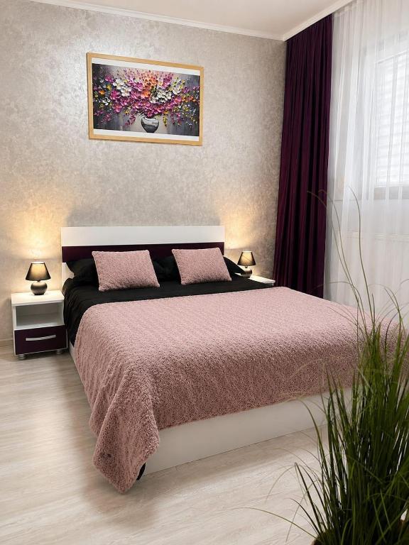 a bedroom with a bed and a painting on the wall at ROYAL MIRAGE Militari Residence in Chiajna