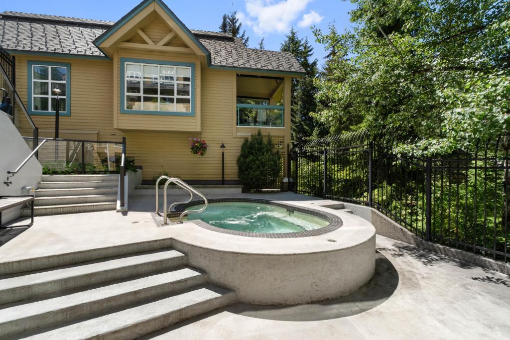 a home with a jacuzzi in the backyard at The Snowbird by Whiski Jack in Whistler