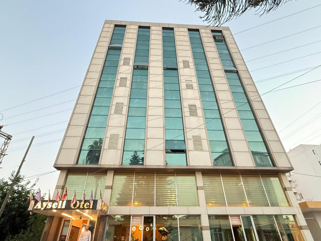 a tall building with glass windows at Ayseli Hotel in Mersin