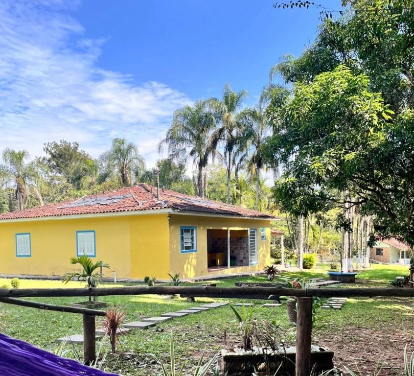 a yellow house with a fence in front of it at Villa Dona Jaca - Casa da Mata - Casa 02 in Socorro