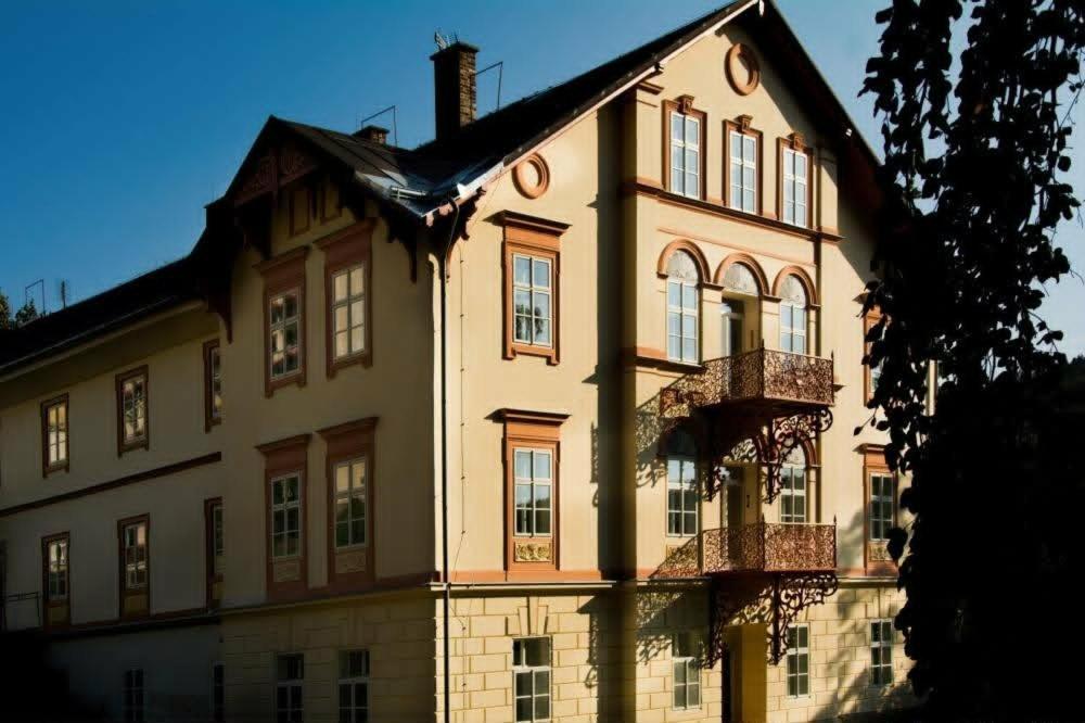 a large building with a balcony in front of it at Apartmány Karina in Janske Lazne