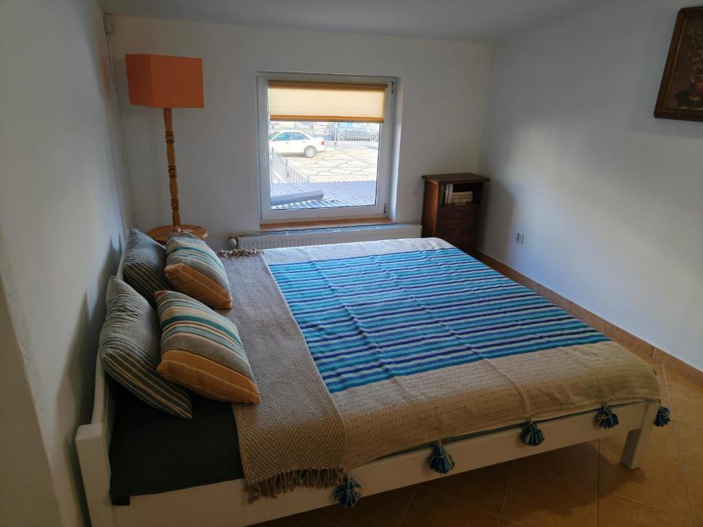 a bed in a room with a window at Studio dwupokojowe z łazienką i kuchnią in Augustów