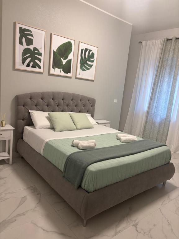 a bedroom with a large bed with green sheets at Karma apartment in Catania