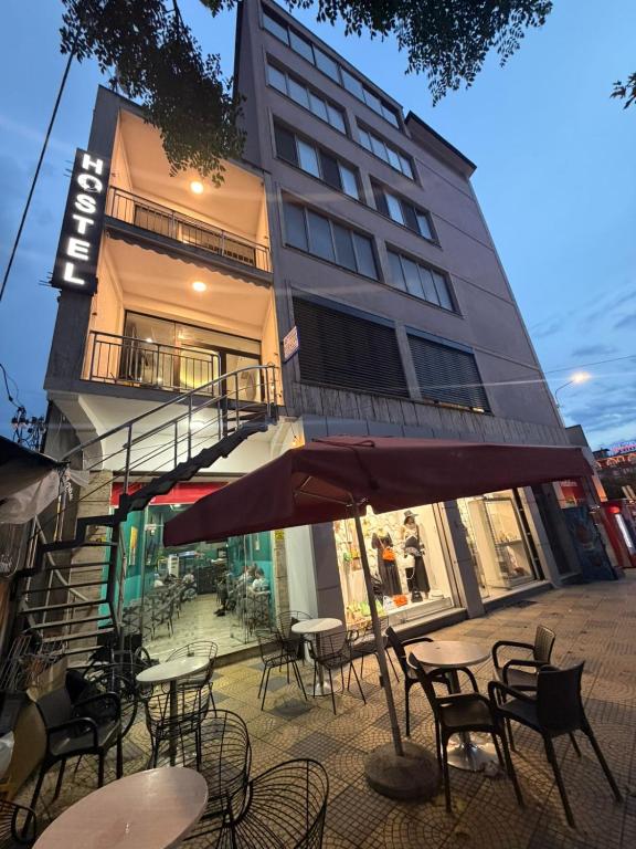 a group of tables and chairs in front of a building at Englishman Hostel Shkoder Backpackers Instant Sleep in Shkodër