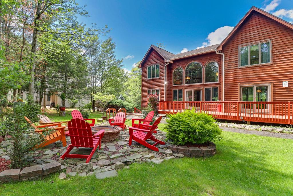 a yard with red chairs and a house at Split Rock Resort: Family Getaway w/ Fire Pit! in Lake Harmony