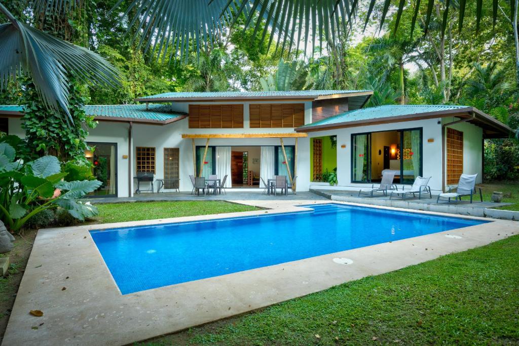 a house with a swimming pool in front of it at Villa Cabu & Casa Color Caribe in Punta Uva
