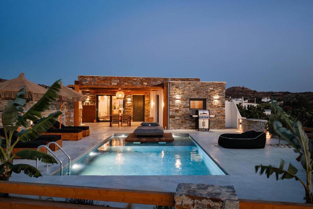 a swimming pool in the middle of a house at Stone Waves Αpartments & Villas in Agios Arsenios