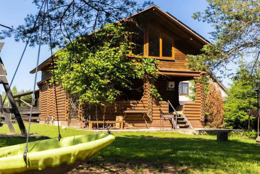 a log cabin with a bunch of bananas in front of it at Green park residence in Tīnūži