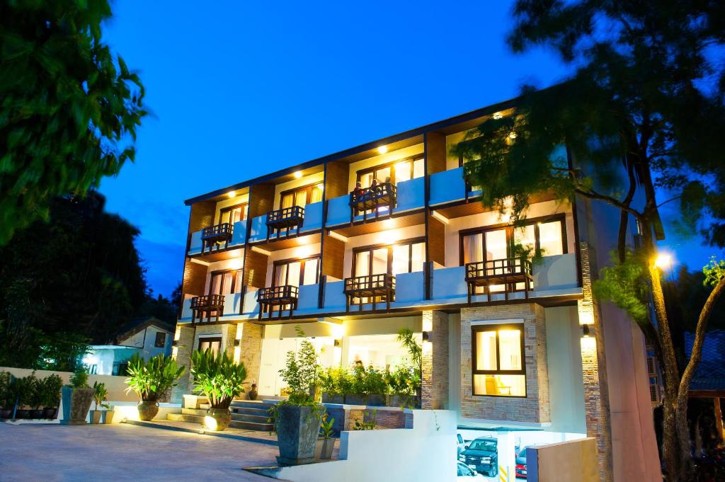 an apartment building with lights on at night at Montien House - SHA Plus in Chaweng