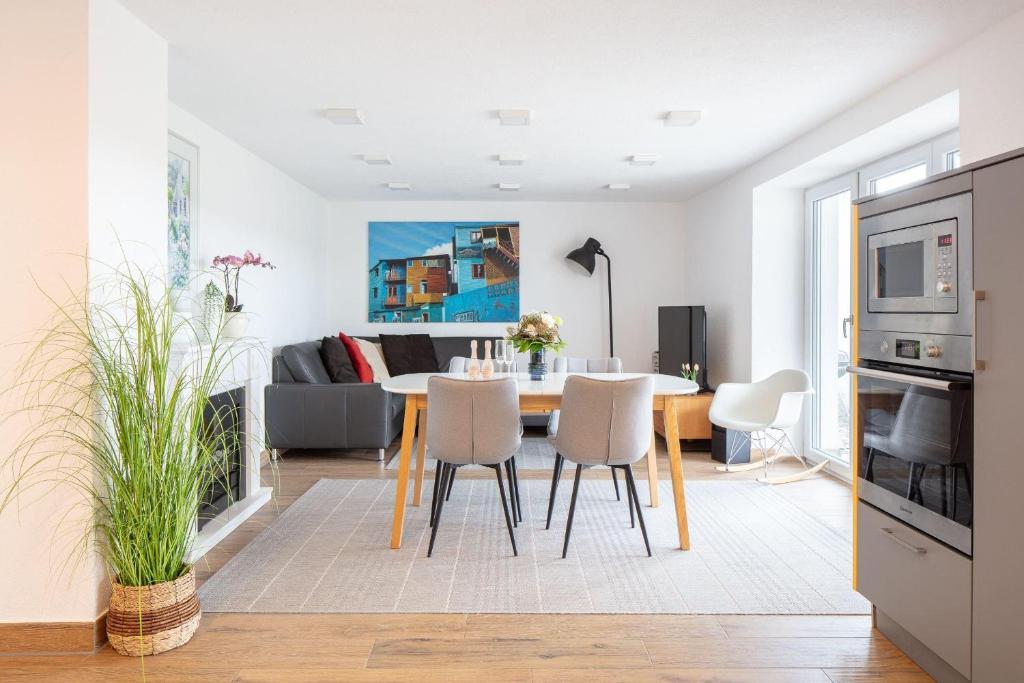 a dining room and living room with a table and chairs at Ferienwohnung Süßenmühle Naturstrand in Sipplingen