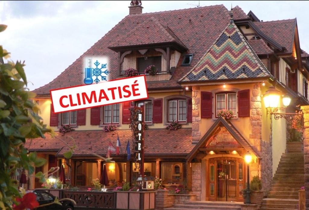 a house with a sign in front of it at Hôtel Le Mittelwihr in Mittelwihr