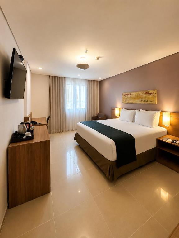 a hotel room with a bed and a flat screen tv at Blue Tree Premium Manaus in Manaus