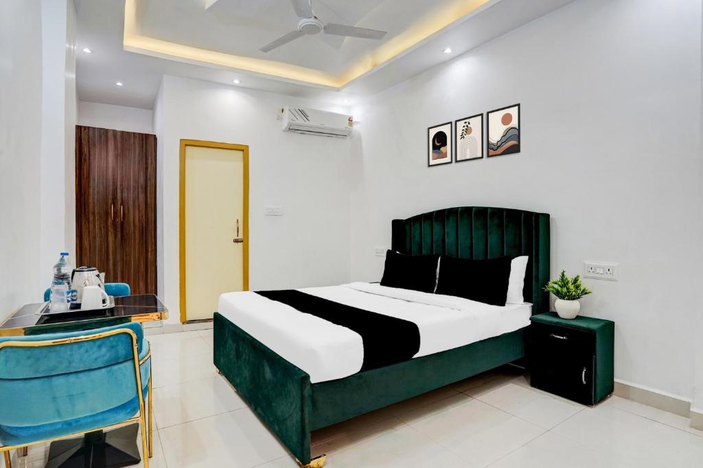 a bedroom with a bed and a blue chair at Hotel O Jaimantri Palace in Bihār Sharīf