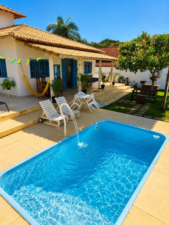 a pool with a fountain in the middle of a house at Piratas Guest Rooms II in Búzios