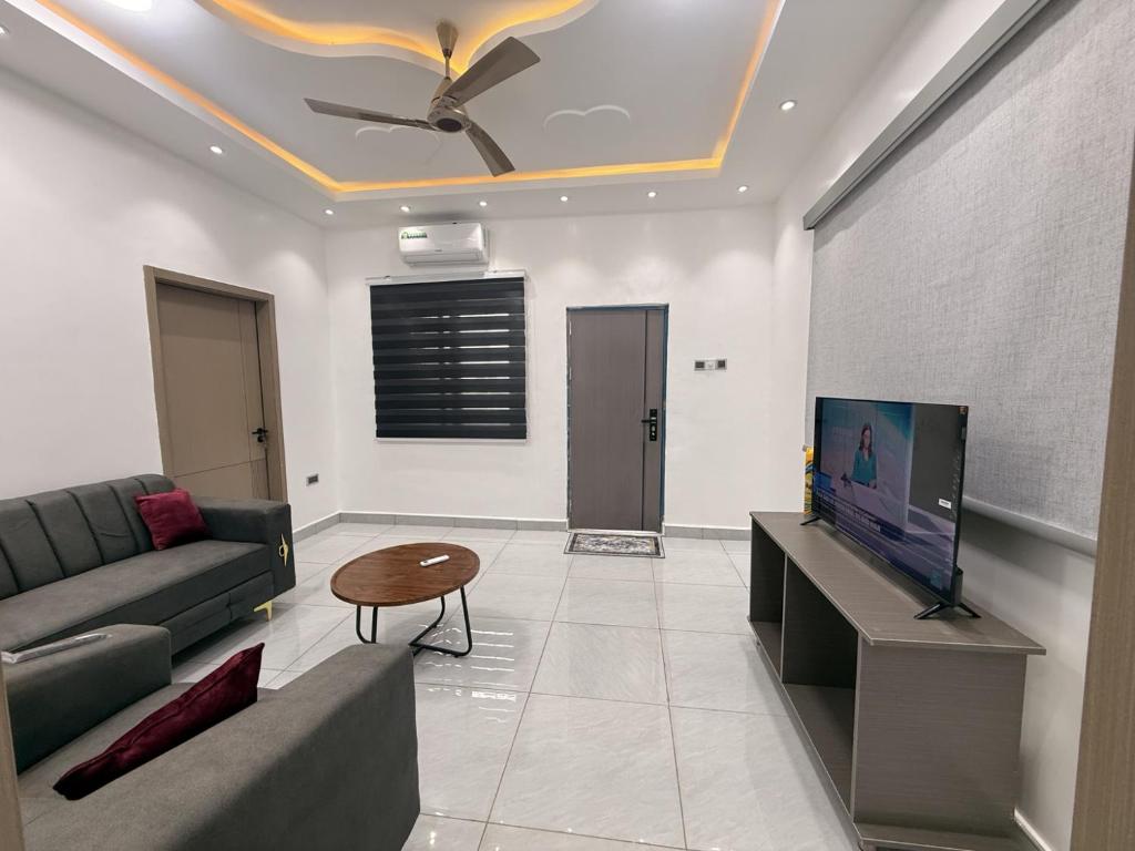 a living room with a couch and a flat screen tv at Maatambaba Homes in Tamale