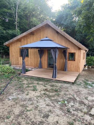 a wooden cabin with an umbrella on a deck at L'erable in Montlay-en-Auxois