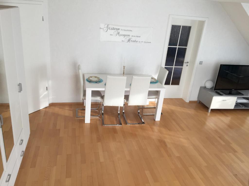 comedor con mesa, sillas y TV en Schwarzwald Appartment en Freudenstadt