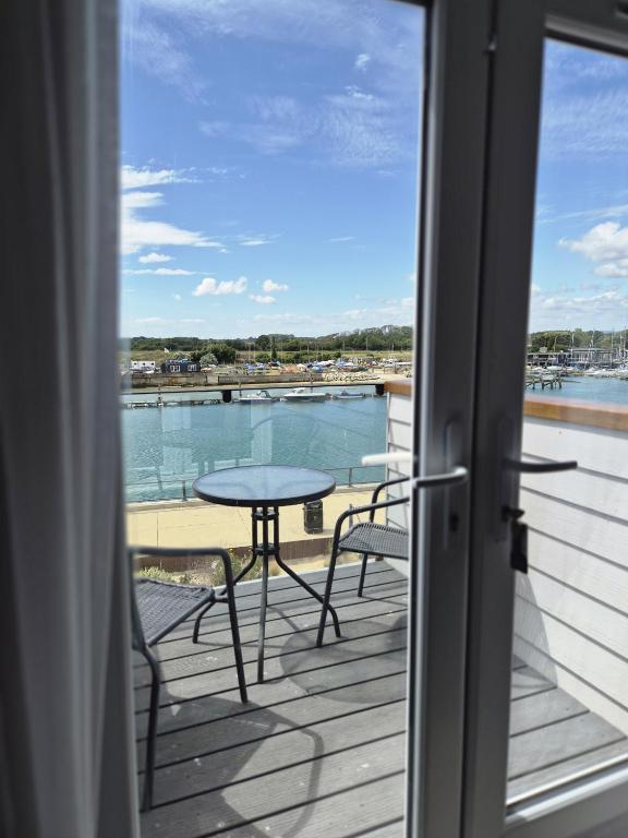 a patio with a table and chairs on a balcony at River Breeze BALCONY 2 in Littlehampton