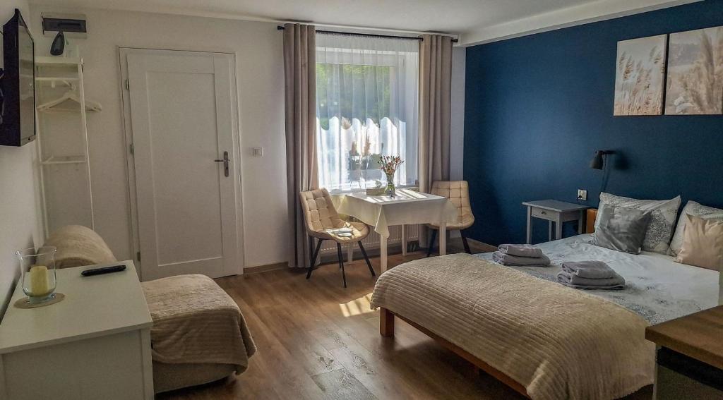 a living room with a bed and a table and a kitchen at Apartamenty Nad Rzeką in Polanica-Zdrój