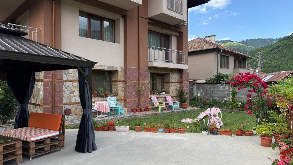 a patio with a gazebo and a garden at Къща за гости Гаджакови in Devin