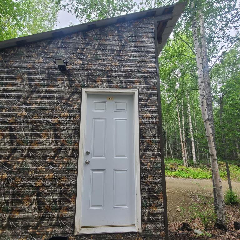 a building with a white door in the front at Adventure Trail Cabin #9 in Houston