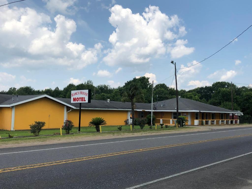 a yellow building with a motel sign on the side of the road at Ranch House Motel in Marksville