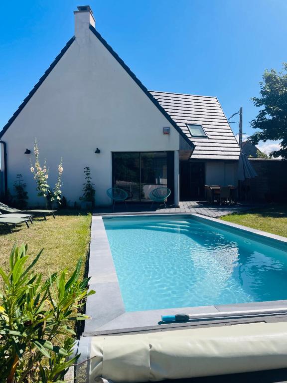 a swimming pool in front of a house at Villa Marius - Piscine - Proche de la plage in Ambleteuse