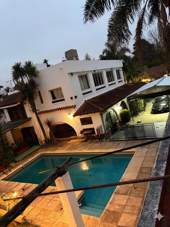 a house with a swimming pool in front of it at HAUS EDELWEISS, Casa Quinta en Monte Grande, Bs As, EZEIZA AIRPORT, GARDEN, SWIMMING POOL in Monte Grande