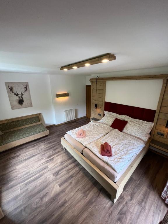 a bedroom with a large bed and wooden floors at Ferienwohnung Lisal in Mutters