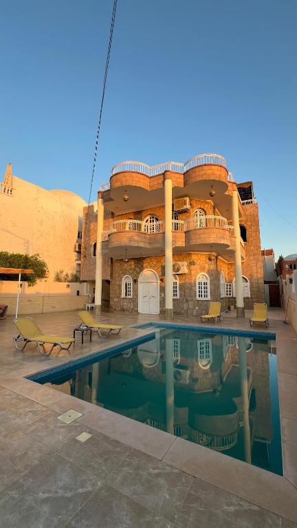 a large building with a swimming pool in front of it at luxor nile palace in Luxor