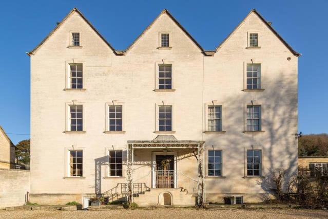 a large white building with a large roof at Grigshot Apartment in Stroud