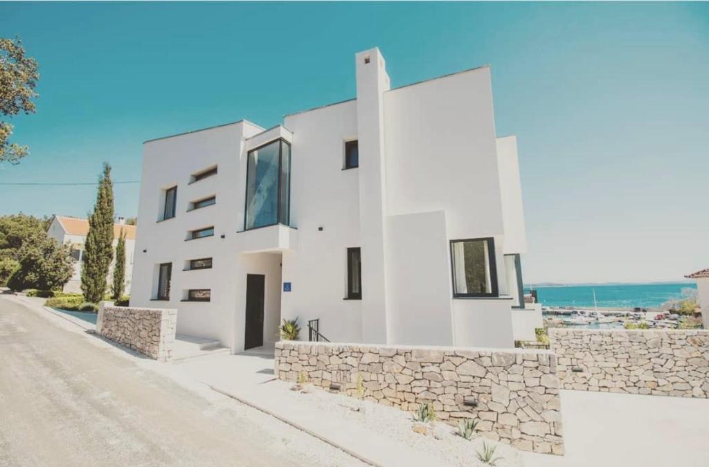 a white house with a stone wall at Sea Star in Žman