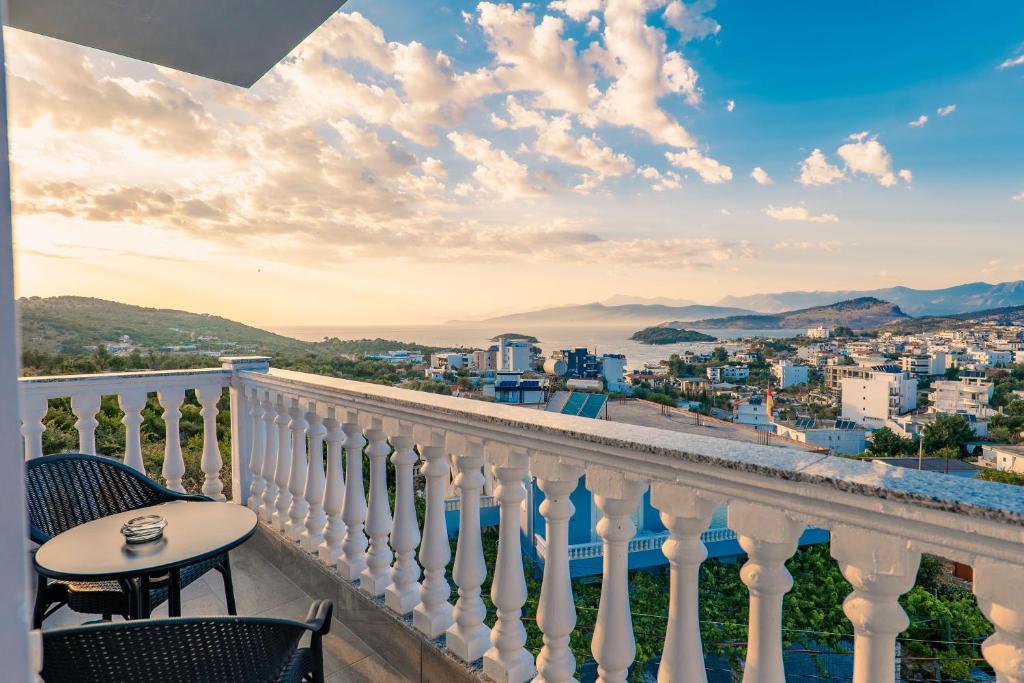 a balcony with a table and chairs overlooking a city at Cloud Nine Retreat, Ksamil in Ksamil