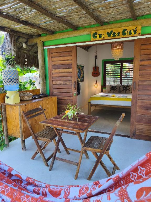 a patio with a table and chairs and a bed at Green Coconut - Icaraí Kite Village in Icaraí