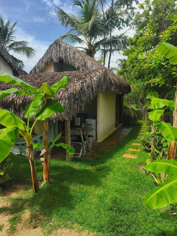 a small hut with a thatched roof at Tiny Cottage in Icaraí
