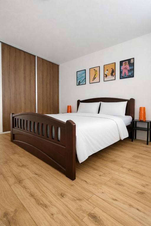 a bedroom with a large bed and wooden floors at Studio11 in Medzilaborce